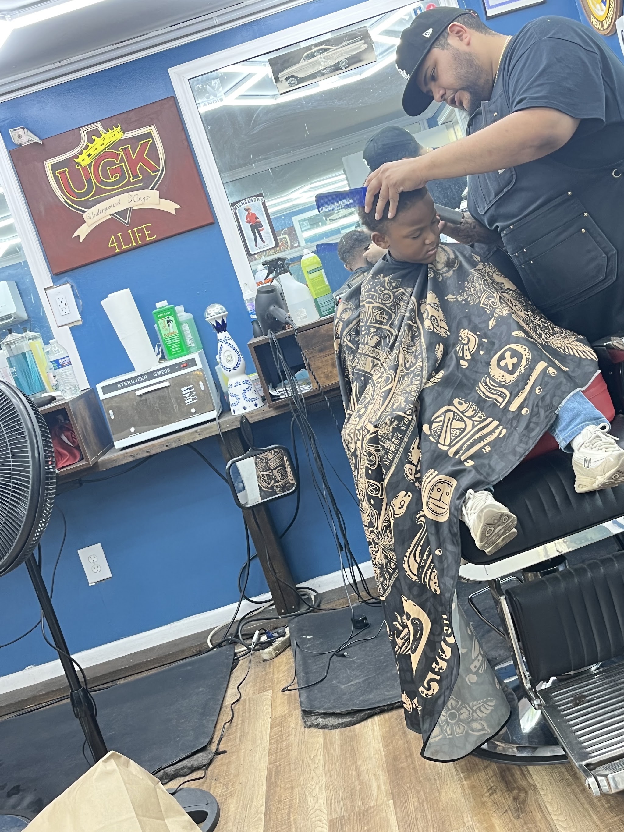 A barber giving a young client a haircut in the shop
