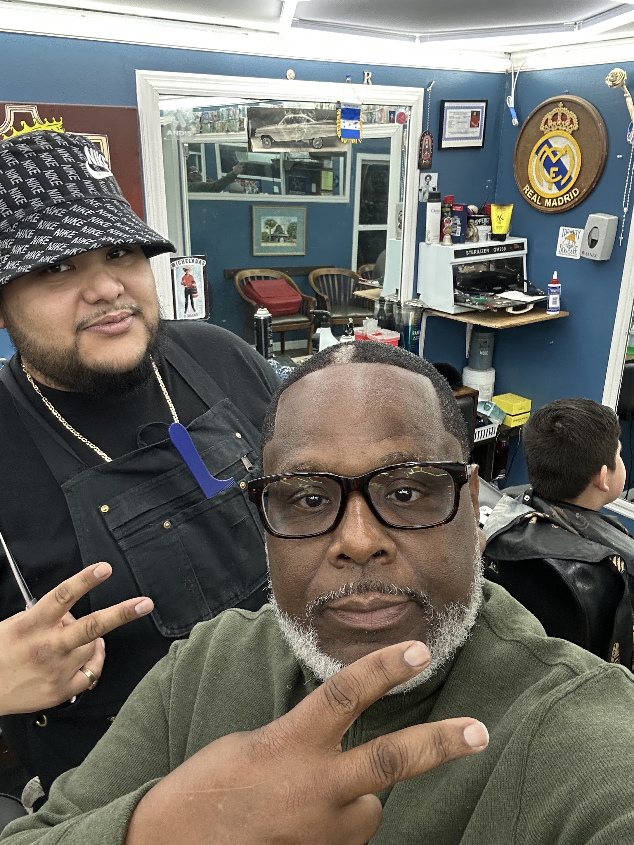 A barber and a client together inside the shop